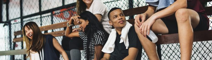 Group of young teenager friends sitting on a bench relaxing