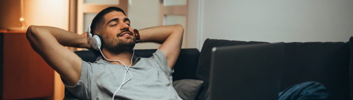 man relaxing in his apartment listening to a music